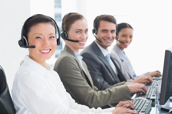 Geschäftsleute mit Headsets, die Computer benutzen — Stockfoto