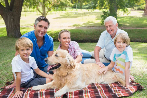 Joyeux famille souriant à la caméra avec leur chien — Photo