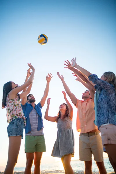 Amigos felices lanzando voleibol — Foto de Stock