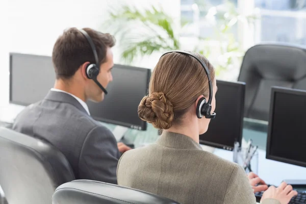 Hommes d'affaires avec écouteurs utilisant des ordinateurs — Photo