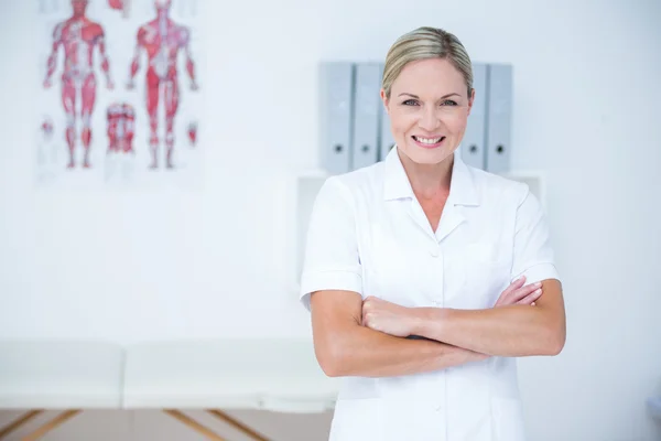 Happy doctor looking at camera with arms crossed — Stock Photo, Image