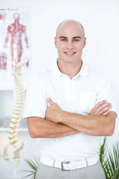 Felice medico guardando la fotocamera con le braccia incrociate — Foto Stock