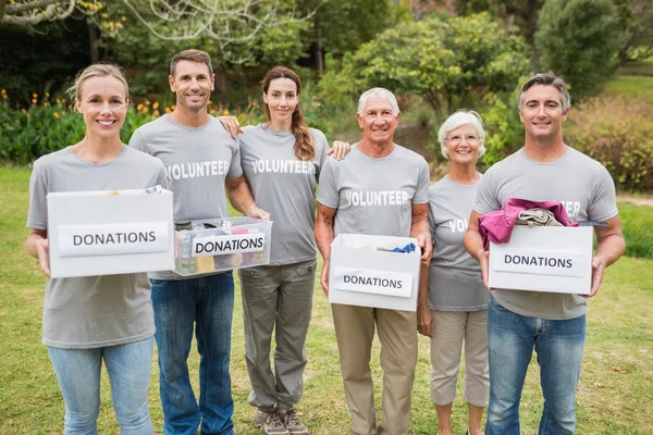 Happy volunteer family holding donations boxes — Stock Photo, Image