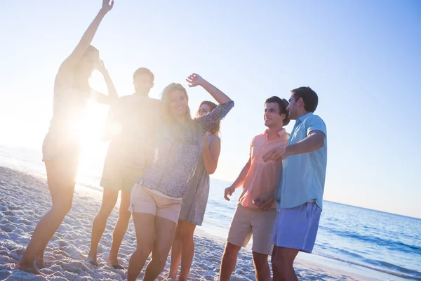 Amigos felizes dançando na areia — Fotografia de Stock