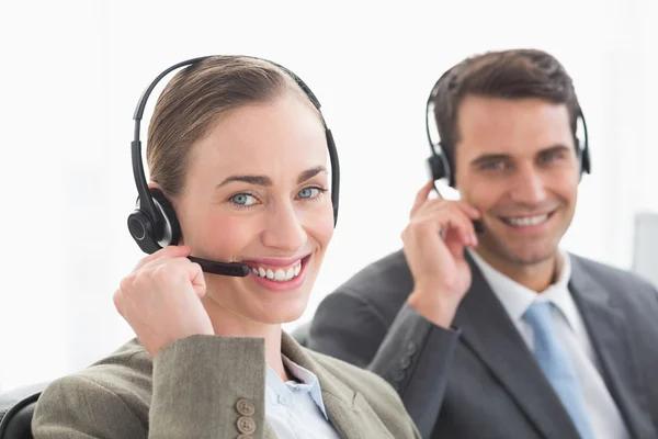 Pessoas de negócios com fones de ouvido sorrindo para a câmera — Fotografia de Stock