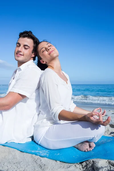 Lyckliga paret gör yoga vid vattnet — Stockfoto