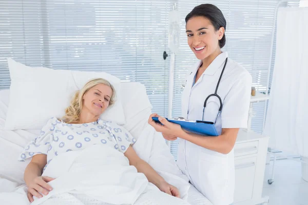 Médico sonriente de pie junto a su paciente — Foto de Stock