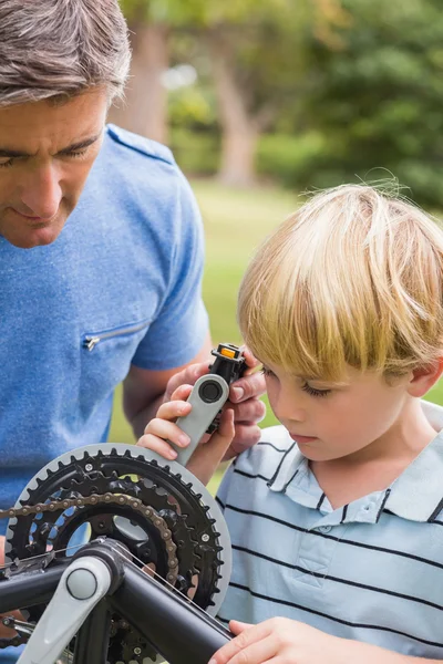 Pai e seu filho consertando uma bicicleta — Fotografia de Stock