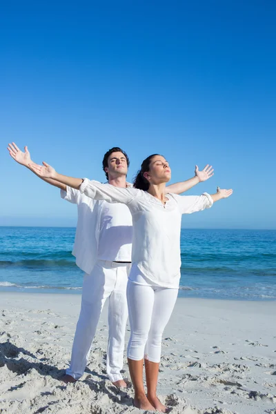 Glückliches Paar beim Yoga neben dem Wasser — Stockfoto