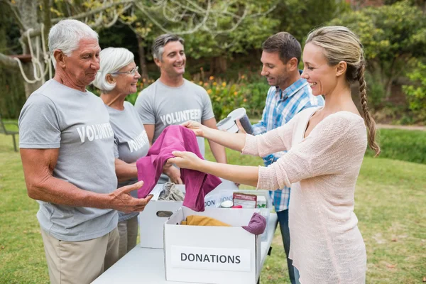 Felices voluntarios de la familia separando las donaciones —  Fotos de Stock