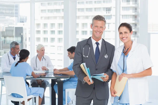 Mannelijke en vrouwelijke artsen met rapporten — Stockfoto