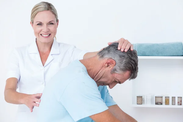 Doctor stretching a man back — Stock Photo, Image