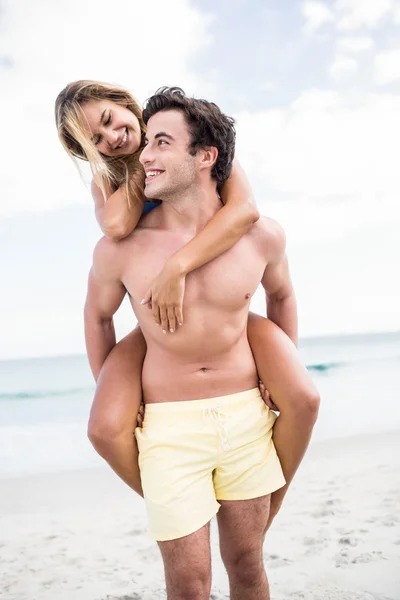 Bonito homem dando porquinho de volta para sua namorada — Fotografia de Stock