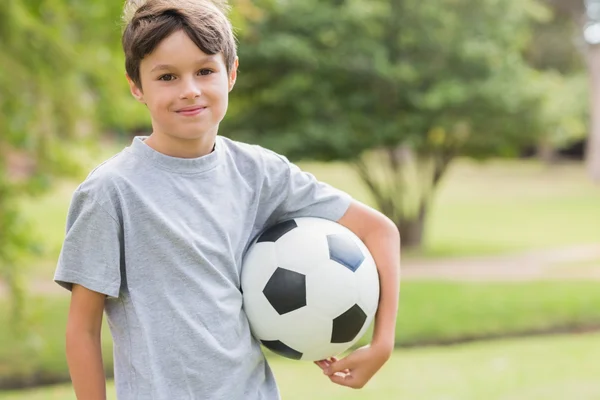 Lachende jongen houden een voetbal in het park — Stockfoto