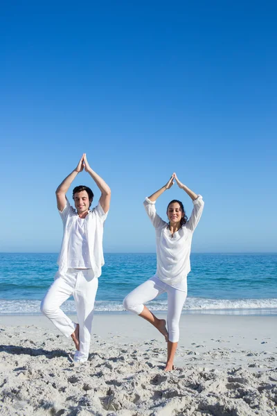Szczęśliwa para robi joga obok wody — Zdjęcie stockowe