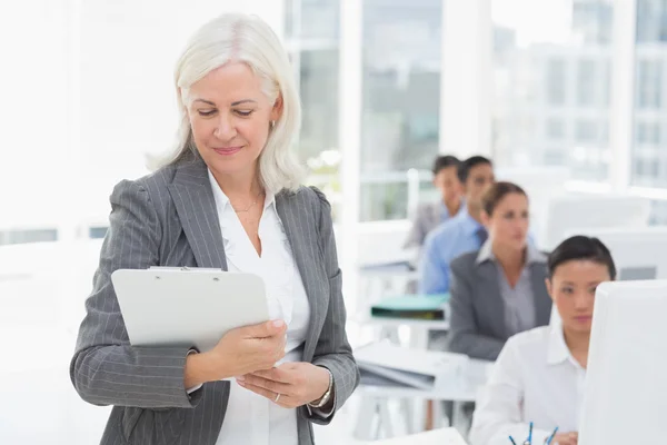 Geschäftsfrau überprüft ihr Klemmbrett — Stockfoto