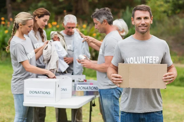 Família voluntária feliz segurando caixas de doação — Fotografia de Stock