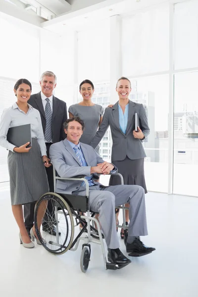 Empresario discapacitado con sus colegas sonriendo a la cámara — Foto de Stock