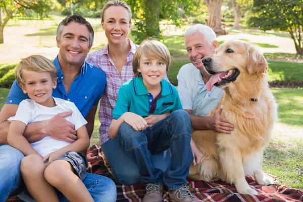 Famiglia felice sorridente alla fotocamera con il loro cane — Foto Stock