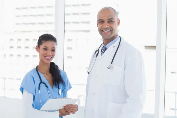 Médicos sonrientes mirando la cámara — Foto de Stock