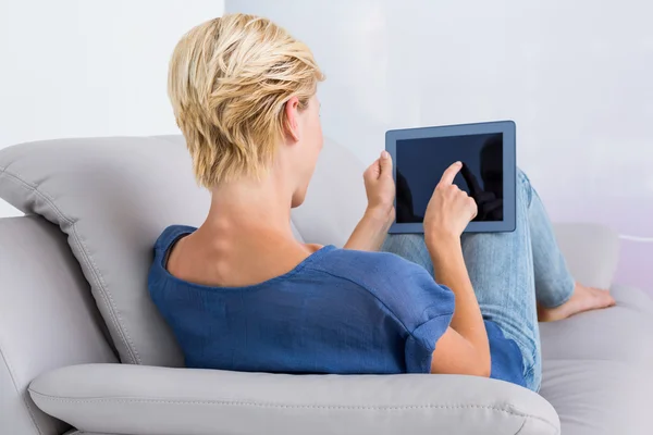 Женщина, использующая свой планшет на диване — стоковое фото