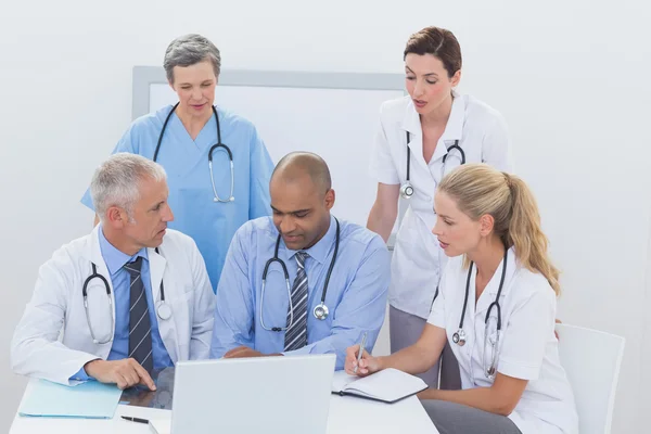 Equipe de médicos que trabalham no laptop — Fotografia de Stock