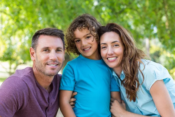 Happy family kissing at camera in the park — Stock Photo, Image