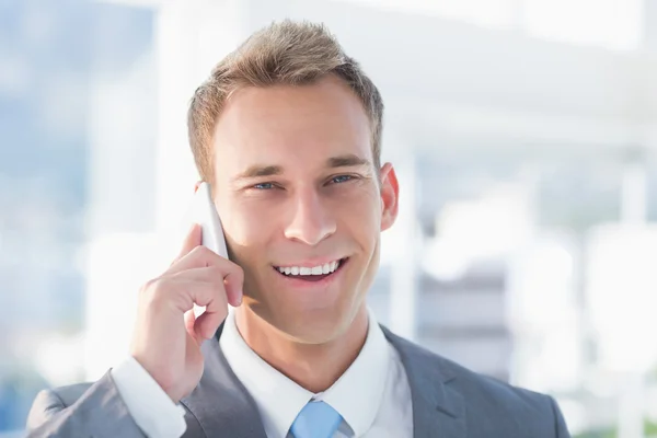 Улыбающийся бизнесмен звонит по телефону — стоковое фото