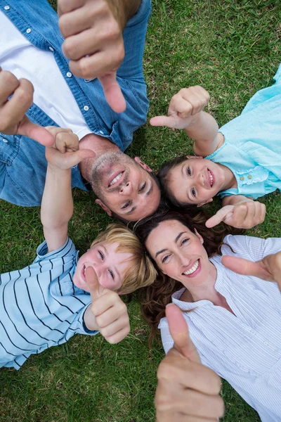 Família feliz no parque juntos polegares para cima — Fotografia de Stock