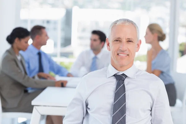 Smiling businessman and his team — Stock Photo, Image