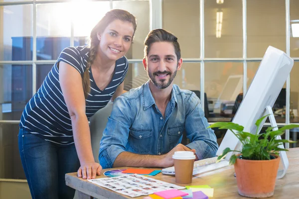 Colegas sorridentes trabalhando juntos no computador — Fotografia de Stock