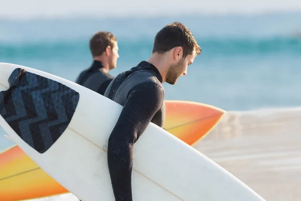 Uomini in muta con tavola da surf in spiaggia — Foto Stock