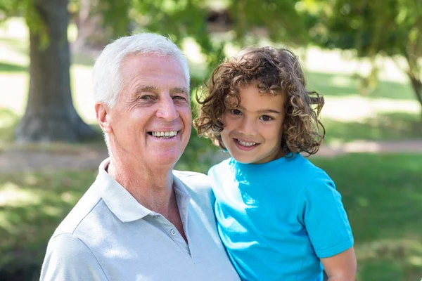 Grandfather and grandson having fun in a park — Stockfoto