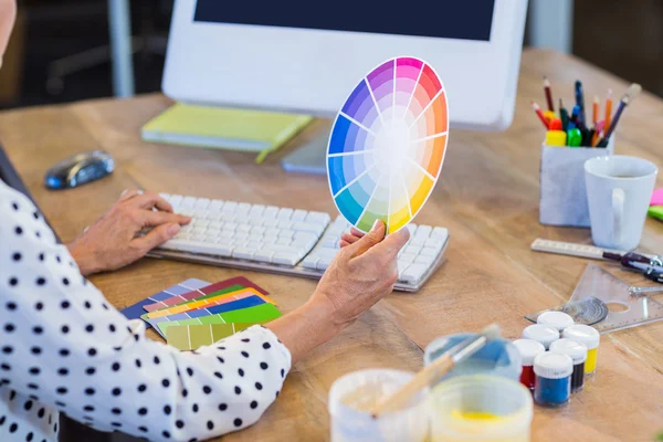 Empresária casual trabalhando com computador e cartela de cores — Fotografia de Stock