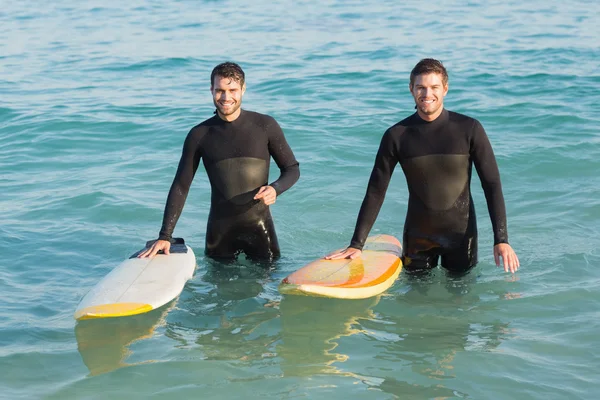 Homens de fato de mergulho com prancha de surf na praia — Fotografia de Stock