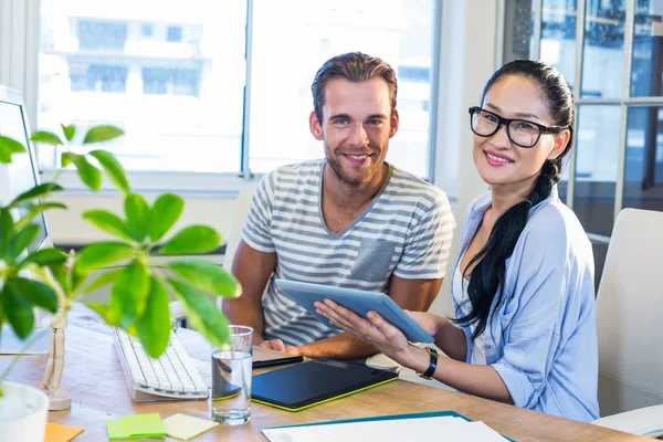 Smiling partners working together on tablet — Stok fotoğraf