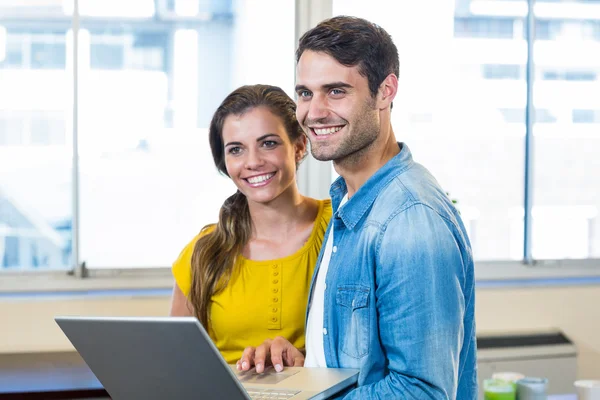Casual business partners holding laptop — Stock Photo, Image
