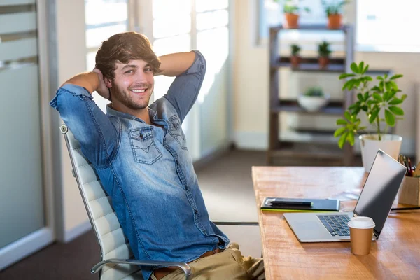 Χαμογελώντας casual επιχειρηματία που κάθεται στο γραφείο — Φωτογραφία Αρχείου