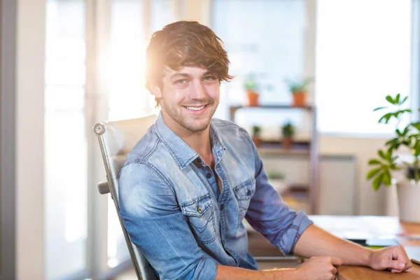 Sonriente hombre de negocios casual sentado en el escritorio —  Fotos de Stock