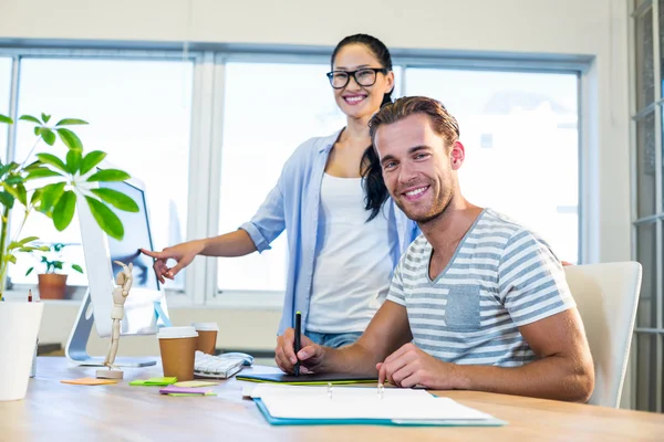 Smiling partners working together on computer — Stockfoto