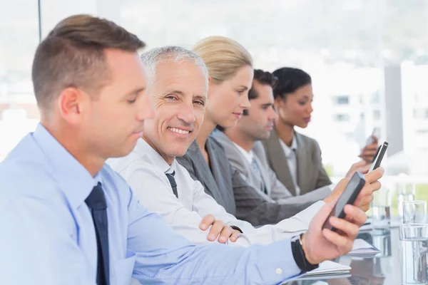 Zakelijke team met behulp van hun mobiele telefoon — Stockfoto