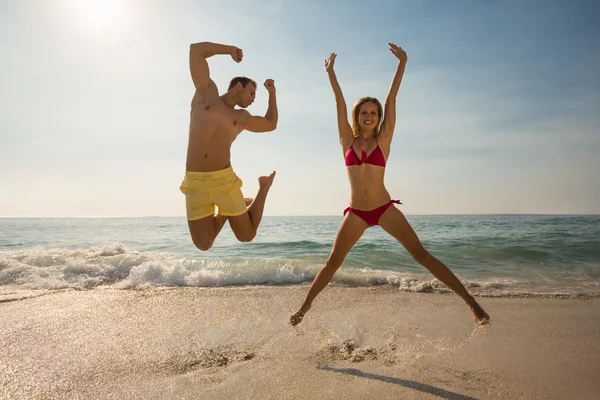 Blondine springt am Strand — Stockfoto