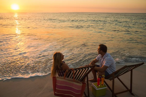 Paar sitzt am Strand — Stockfoto