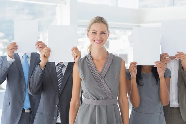 Business colleagues hiding their face with paper — Stock Photo, Image