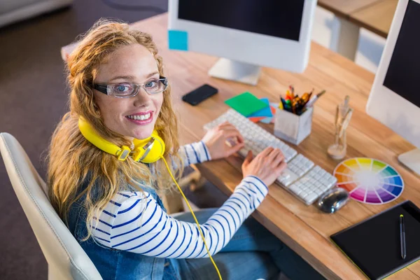 Desenhista sorridente digitando no teclado — Fotografia de Stock