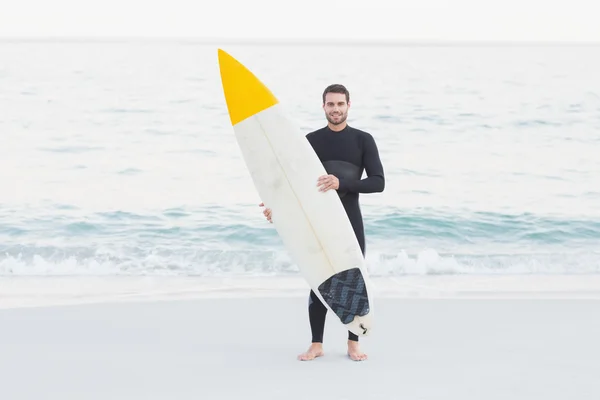 Uomo in muta con tavola da surf in spiaggia — Foto Stock