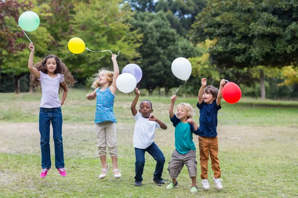 Счастливые дети держат воздушные шары — стоковое фото