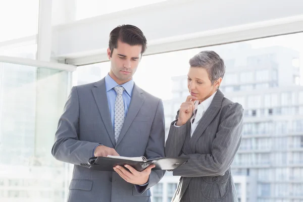 Businessman showing notes to colleague — Stock Photo, Image