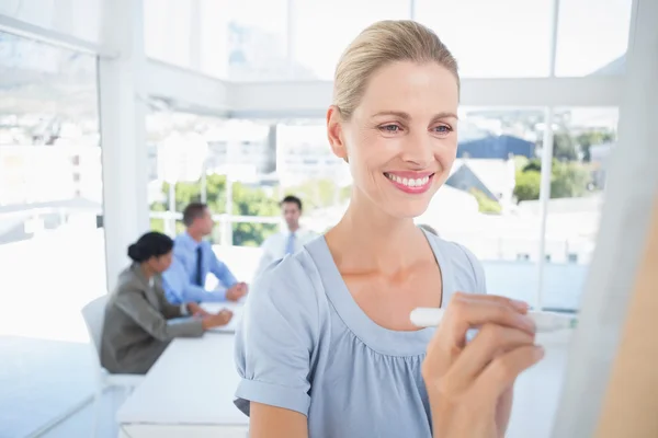 Businesswoman writing brainstorming ideas on board — 图库照片