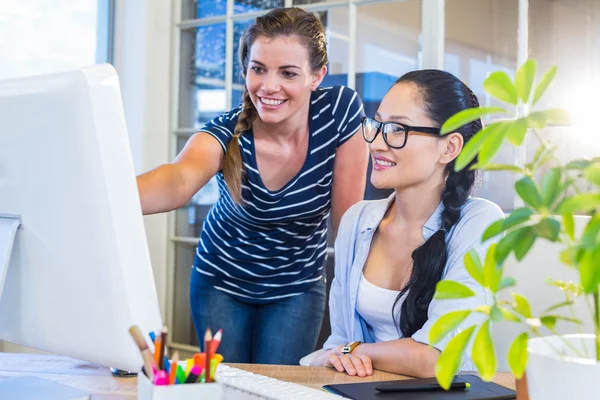 Smiling partners working together on computer — Stockfoto